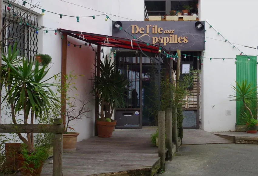 restaurant avec une entrée décorée de plantes et guirlandes lumineuses sur l'île d'Oléron