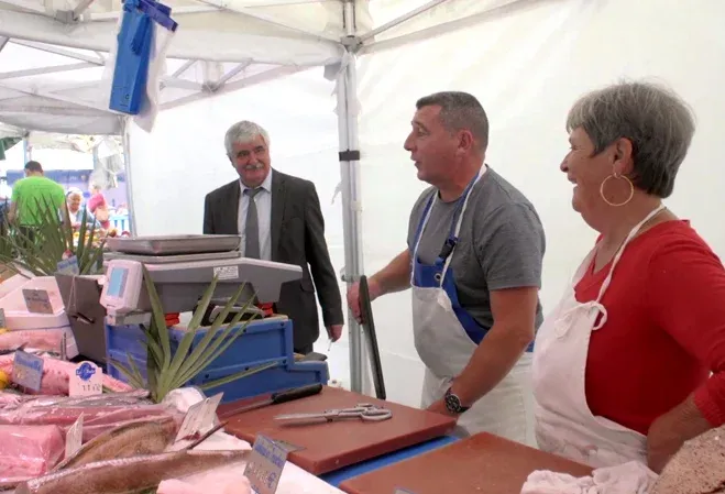 Jean-Pierre Quevilly, poissonnier et Franci Frando, inspecteur-indemnisateur MAPA en train de parler sur le stand du poissonnier du marché de Levallois-Perret