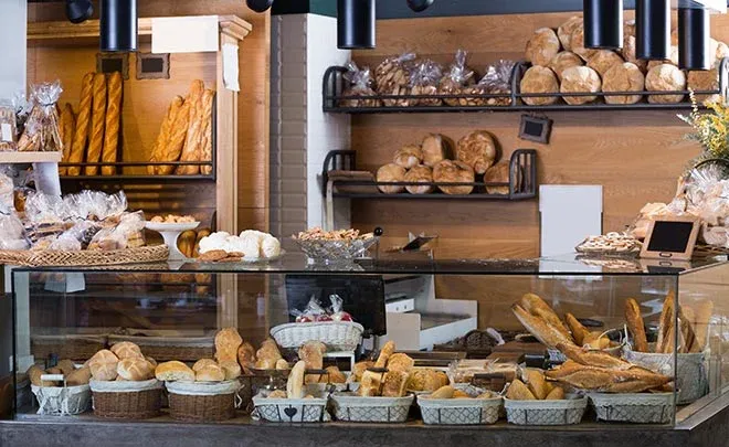 vitrine d'une boulangerie avec pains baguettes et viennoiseries en présentoir